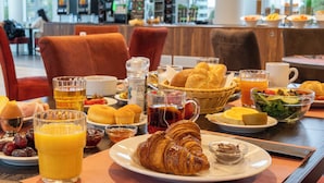 A breakfast buffet with croissants, fruits, and beverages. - PLAZA Premium Almere (Almere)