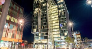 A modern high-rise building with multiple floors, large windows, and a well-lit facade. - PLAZA Premium Almere (Almere)