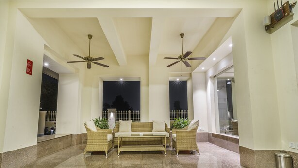 A lobby with a seating area, ceiling fans, and a view of the outside. - Zade House Jaipur (Jaipur)