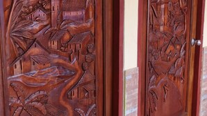 Dos puertas de madera con intrincados grabados de paisajes y edificios.