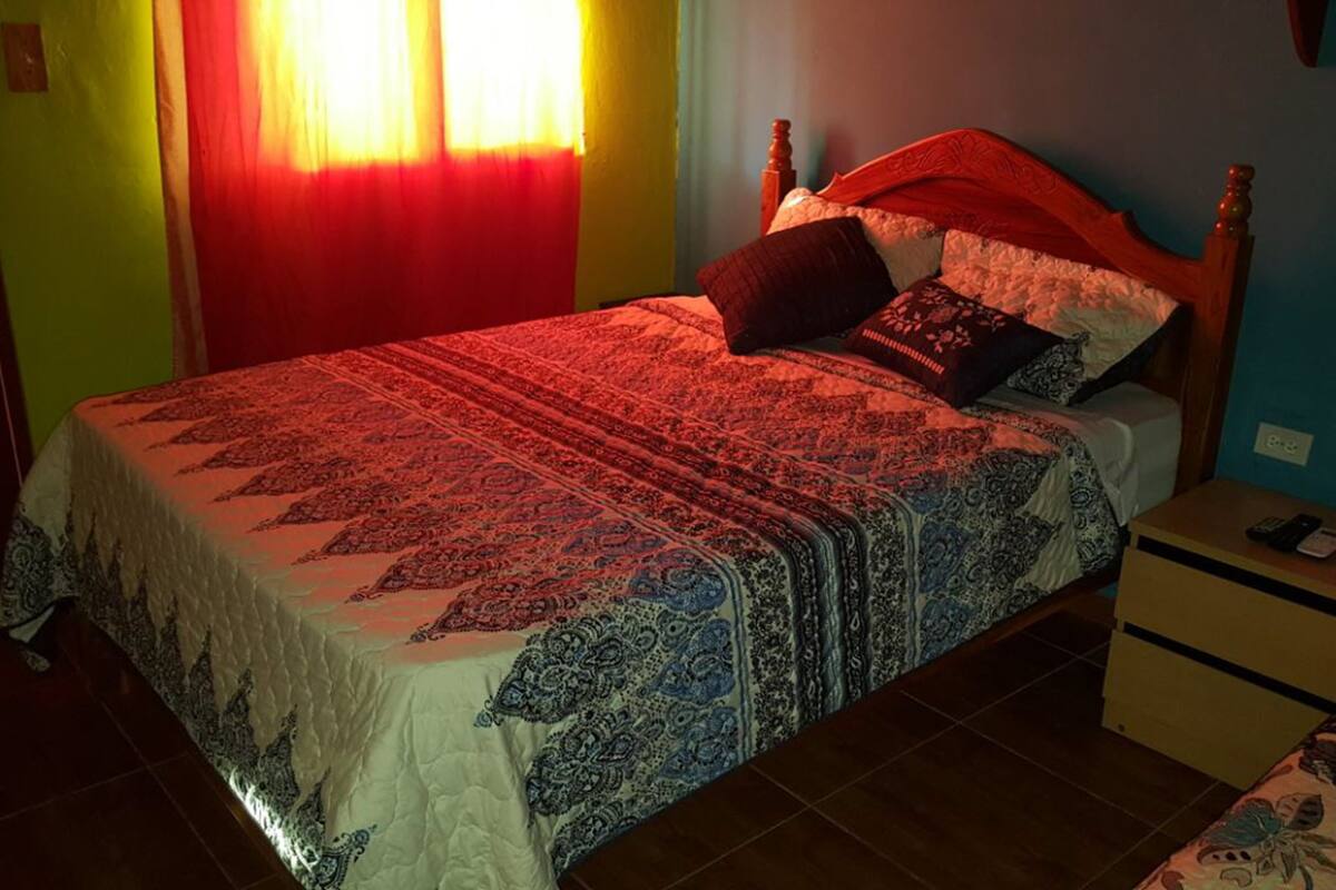A bedroom with a bed, nightstand, and a small table.
