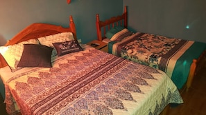 Un dormitorio con dos camas, cada una con cabecero de madera y colcha estampada.