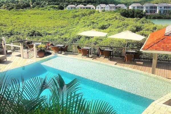 Una piscina al aire libre, sillones reclinables de piscina