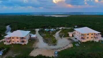 A resort with two large buildings, a swimming pool, and a beach view.