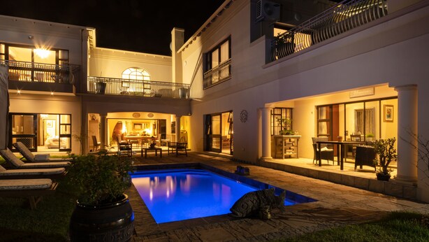 A two-story house with a swimming pool, outdoor seating, and a cat on the patio. - Amery House (Gqeberha (Port Elizabeth))