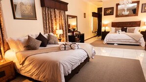 A hotel room with a large bed, a smaller bed, a desk, and a chair. There are two lamps on either side of the room. - Amery House (Gqeberha (Port Elizabeth))