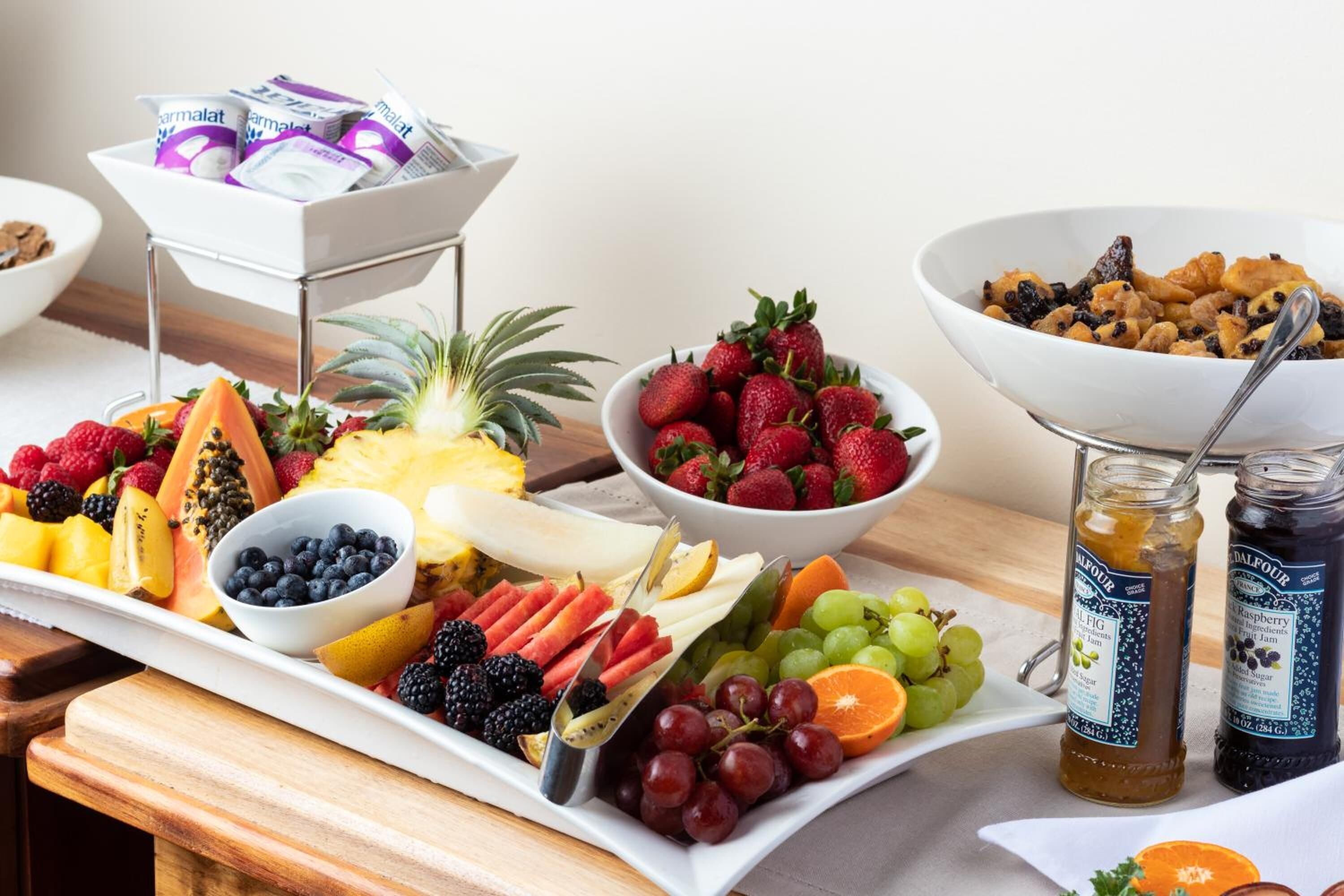 A safata de fruita amb diverses fruites i dos pots de melmelada.