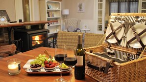 A cozy dining area with a wooden table set for a meal, a wine bottle, and a basket of cutlery. - Mount Tomah Huntington Lodge - peaceful & picturesque Hamptons styled hideaway  (Mount Tomah)