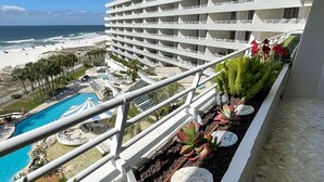 A hotel with multiple balconies overlooking a beach and a pool area. - Gulf Front Condo with Stunning Views! (Pensacola)