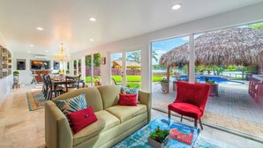 A spacious living area with a sofa, a red armchair, and a glass coffee table.