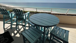 A terrace with a round table and four chairs, overlooking a beach. - Eden West 905 Completely updated Gulf Front Condo with Stunning Views! (Pensacola)