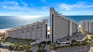 A multi-story hotel with a unique architectural design, featuring a prominent tower and a large parking area. - Updated W 700 1 Bedroom 2 Bath Gulf Front Condo with Stunning Views! (Pensacola)