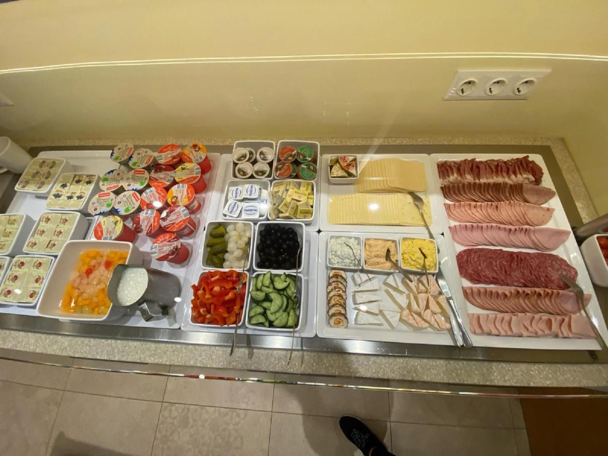 A buffet with various food options including meats, cheeses, and vegetables.