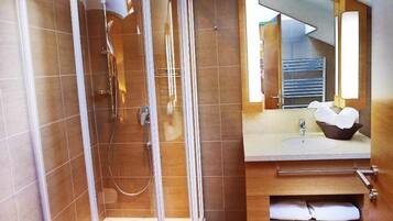 Une salle de bain moderne avec une douche à parois de verre, un meuble-lavabo en bois et des toilettes.