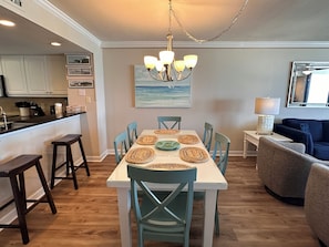 A dining area with a table, chairs, and a chandelier.