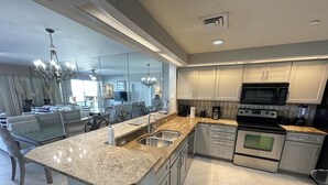Een moderne keuken met granieten werkbladen, roestvrijstalen apparatuur en een centraal kookeiland.