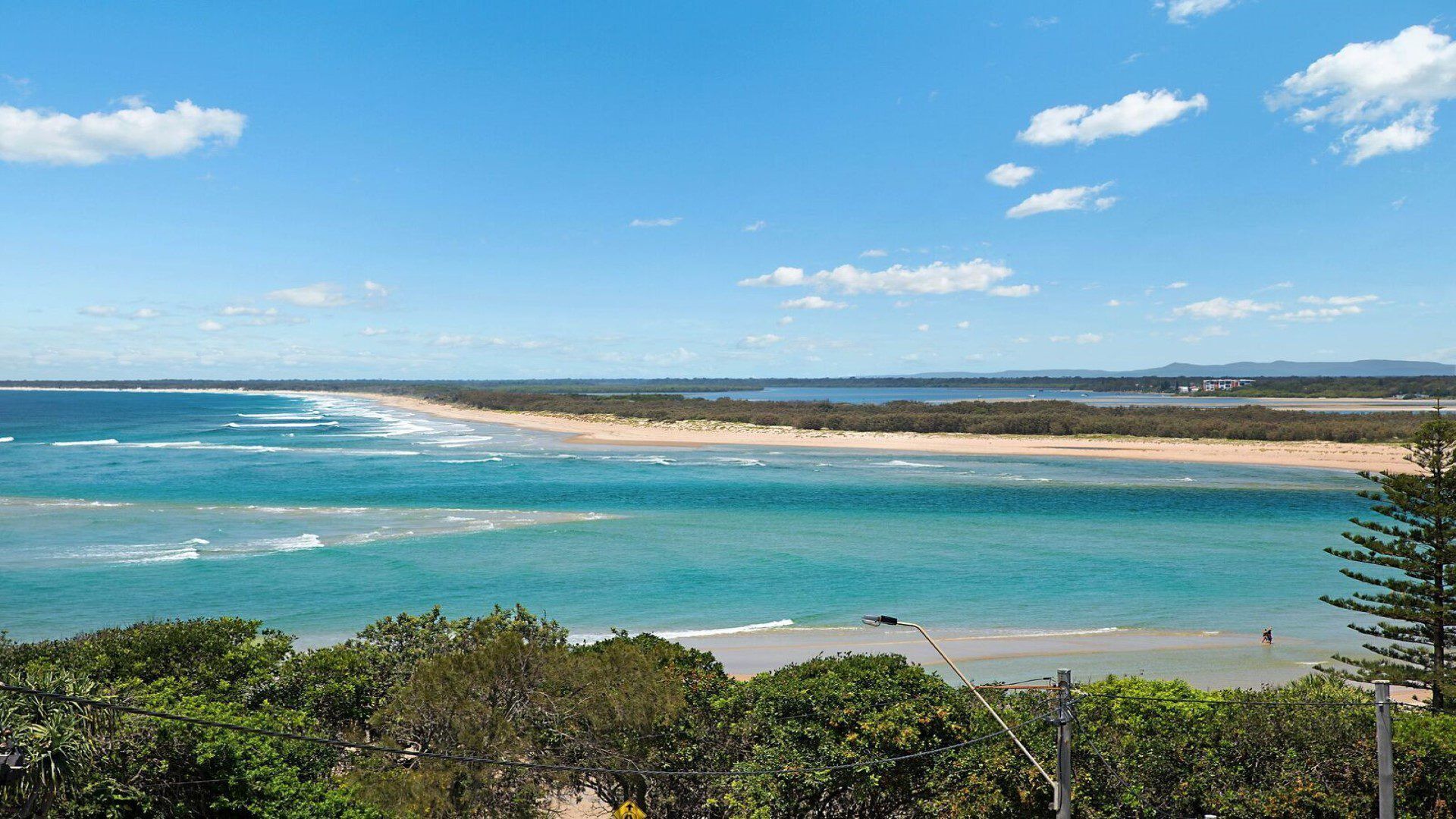 Un paysage côtier caractérisé par une eau d’un bleu limpide, des plages de sable et une végétation luxuriante.