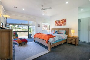 Une chambre à coucher avec un lit, une table de chevet et une vue sur l’extérieur.