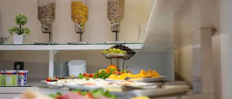 A buffet setup with various food items and a small potted plant.