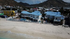 A beachside resort with a pool area, beachfront villas, and a view of the ocean and mountains. - Beautiful beachfront at The Villas On Great Bay (Philipsburg)