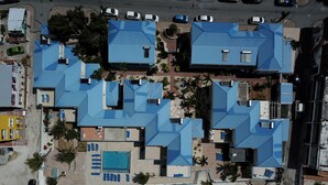 An aerial view of a resort with multiple buildings, a swimming pool, and a beach area. - Beautiful beachfront at The Villas On Great Bay (Philipsburg)