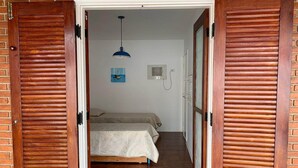 A room with a bed, a ceiling fan, and a wall-mounted air conditioning unit. - 4 suites, air conditioning, TV, internet, swimming pool, 150 meters from the beach! Pets allowed! (Guarujá)