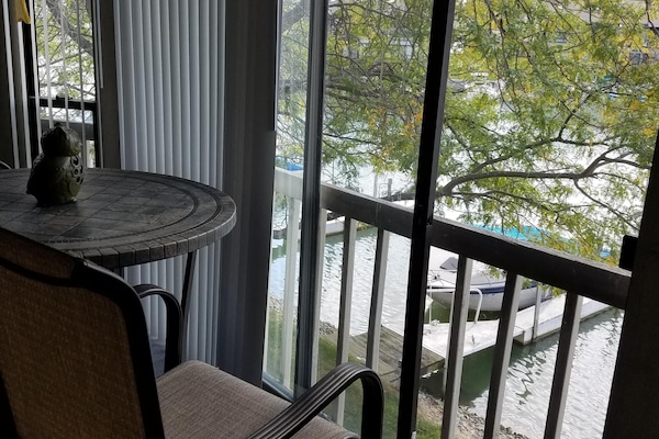 Balcony with table and two chairs. Stair access to dock