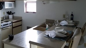 A kitchen with a central island, a microwave, a stove, and a sink. - Lake Erie Green Cove Getaway (Oak Harbor)