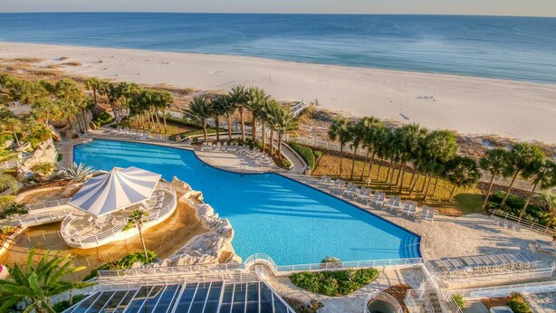 A resort with a large swimming pool, beach access, and palm trees. - Gulf Front Condo with Stunning Views! (Pensacola)