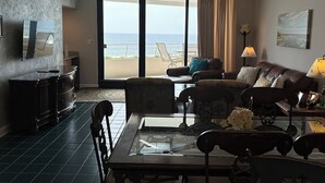Ein Wohnzimmer mit Meerblick, Deckenventilator und einer Kandelaber.