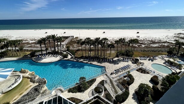 Ein Resort mit großem Pool, einem Strand und freiem Blick auf den Ozean.