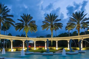 Relax beneath the shade of palm trees and enjoy the soothing sound of a nearby water feature.