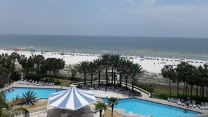Un complexe hôtelier doté d’une piscine, d’une plage et de palmiers.