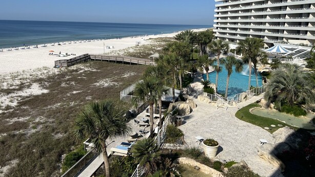Ein Resort mit Strand, Pool und einem großen Hotelgebäude.