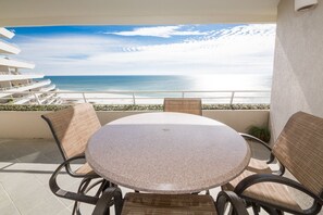 A round table with four chairs on a balcony overlooking a beach. - West 801 Eden Condominiums Gulf Front Condo with Stunning Views! (Pensacola)