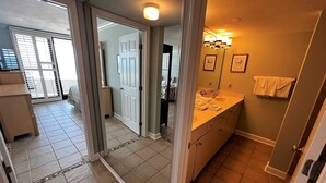 A bathroom with a double sink, a mirror, and a towel hanging on the wall. - Gulf Front Condo with Stunning Views! (Pensacola)