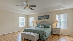 A bedroom with a bed, nightstands, a bench, and a ceiling fan. - Renewed luxury property 20 min from Disney and major parks (Davenport)
