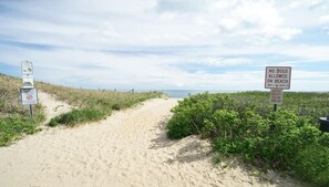 A sandy beach path with signs indicating no dogs allowed on the beach from May 1st to September 15th, and a closed town property sign. - Game Room Walk to Nantucket Sound! (South Chatham)