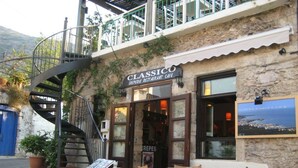 Ein Restaurant namens 'CLASSICO' mit einer Steinfassade, einer Wendeltreppe und Außenplätzen.
