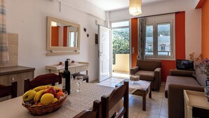 Ein Wohnzimmer mit Essbereich, einer Couch, einem Fernseher und einem Balkon mit Blick.