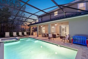Un espace piscine avec des chaises longues, un coin repas et une terrasse couverte.