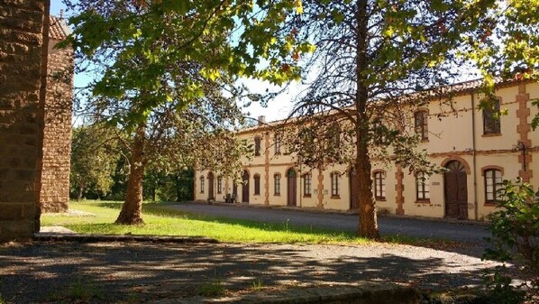 A building with a symmetrical facade, arched windows, and a central entrance. - Charming house located in the Espinalbet area. (Castellar del Riu)
