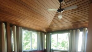 A room with two beds, wooden ceiling, and large windows with curtains. - Apart da Cachoeira (Florianópolis)