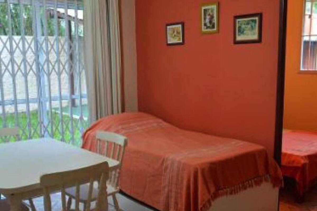 A single room with a bed, a table, and two chairs.