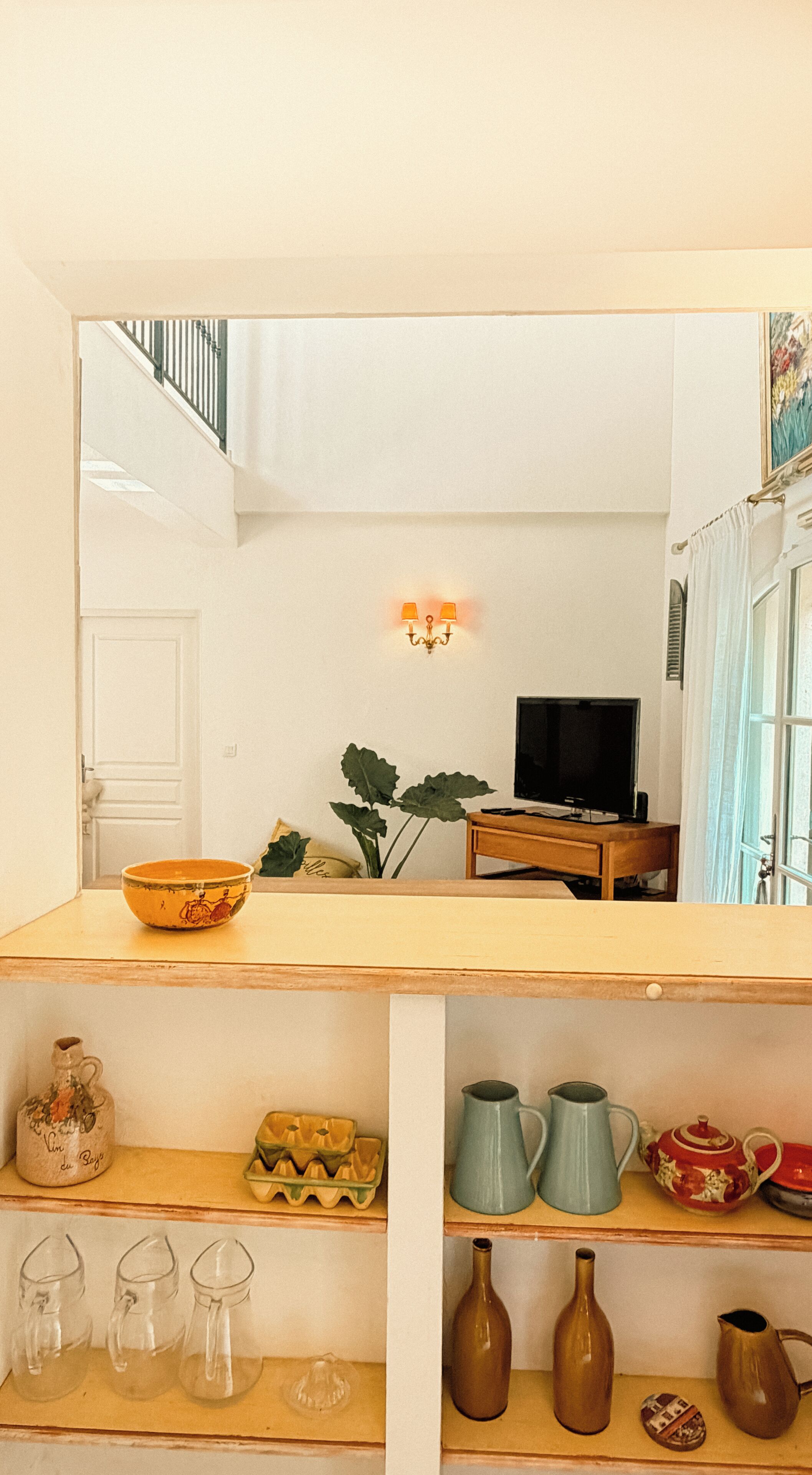 A room with a wooden table, a television, and various decorative items.