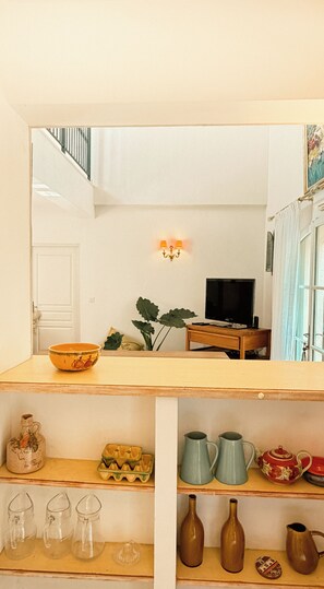 A room with a wooden table, a television, and various decorative items. - Opulent Villa with newly renovated heated pool. 5 minute drive to center (Saint-Rémy-de-Provence)