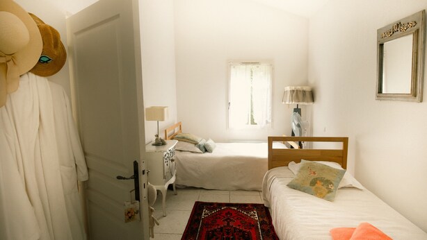 A bedroom with a bed, a nightstand, a dresser, a window, and a mirror. - Opulent Villa with newly renovated heated pool. 5 minute drive to center (Saint-Rémy-de-Provence)