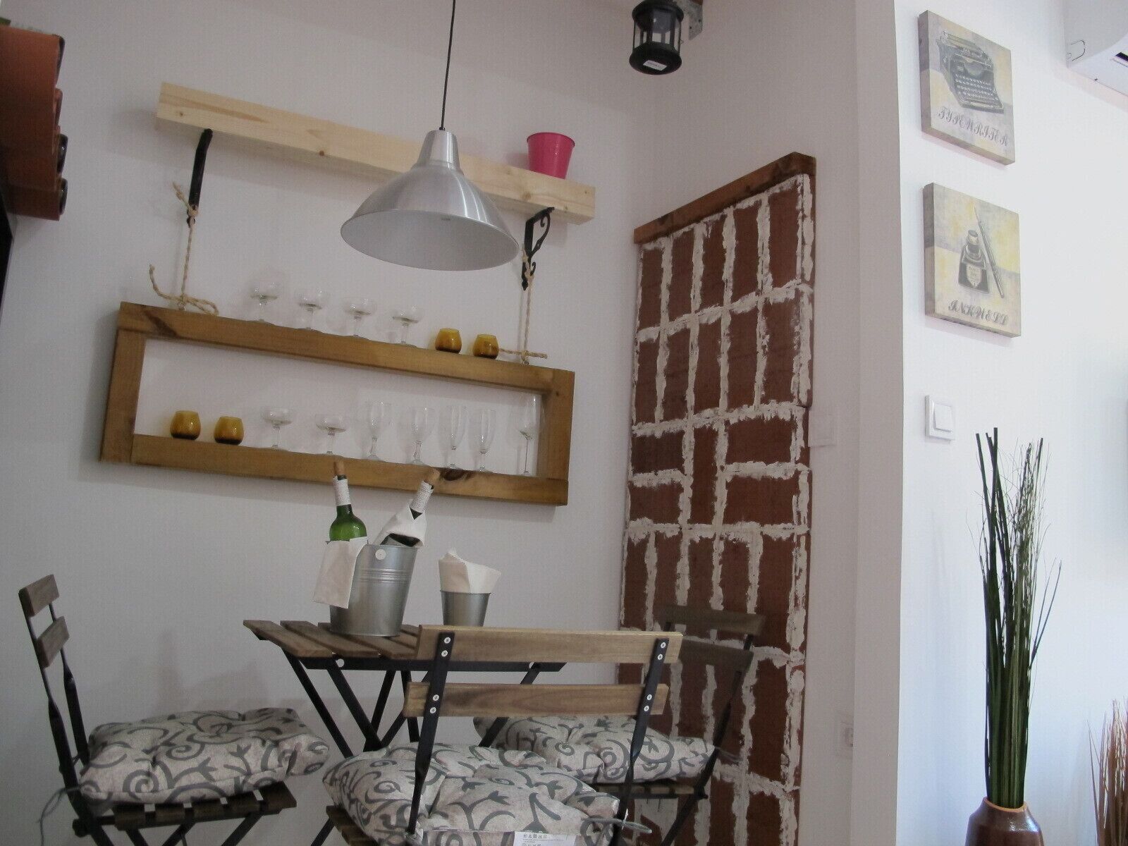 Un comedor con mesa de madera, sillas y una lámpara colgante.