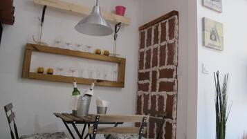 Un comedor con mesa de madera, sillas y una lámpara colgante.