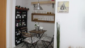 A dining area with a wooden table and chairs, a wine rack, and hanging lanterns.